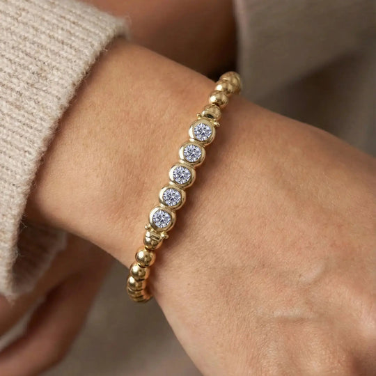 Gold bracelet with embedded diamonds on a wrist